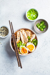 Asian noodle soup ramen with chicken and egg in gray bowl. Japanese food concept.