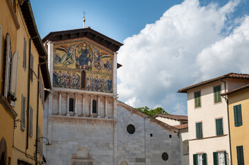Lucca, Tuscany, Italy. August 2020. Detail of the facade of the Basilica of San Frediano. The golden mosaic attracts the eye. Beautiful summer day