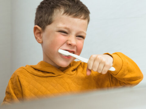 Boy brushing teeth in bathroom