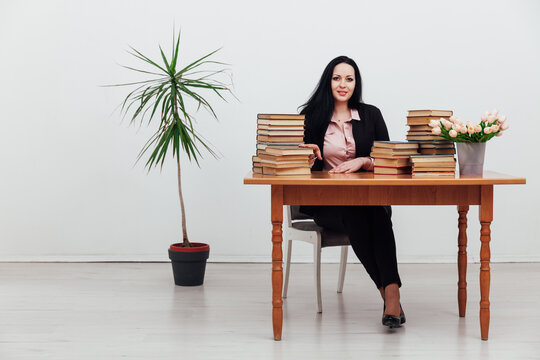 female teacher at a table with books for teaching
