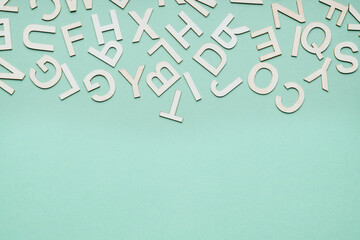 jumble of wooden letters falling down on blue paper background