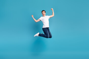 Obraz premium Full body photo of young excited man have fun jumper rejoice victory success isolated over blue color background