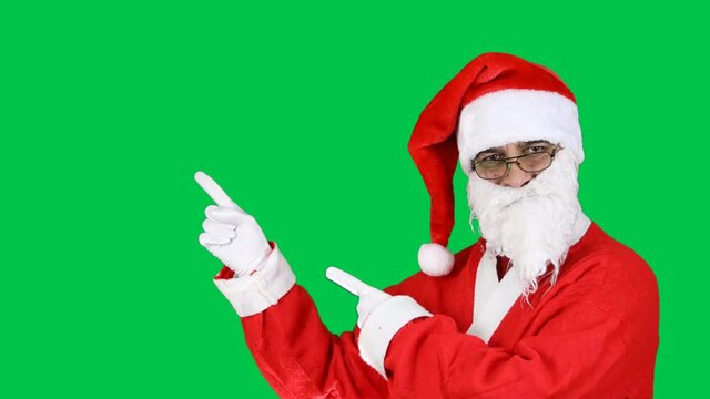 Friendly Santa Claus Pointing with two hands and fingers to the side at Copy Space, Workspace for Advertisement, Empty Place for Text or Image, Promotional Content. 