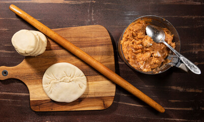  Peparation of  homemade pies with mincemeat filling on the kitchen table at home © vbaleha