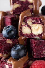 Pieces of beetroot brownie with berries and chocolate. Sugar, gluten and lactose free and vegan.
