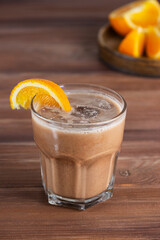 Orange mocha coffee with chocolate and coconut milk in a glass on a wooden table. Sugar, gluten and lactose free.