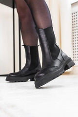 Black elegant winter boots, stylish leather lady footwear. Urban lifestyle, modern fashion concept photo