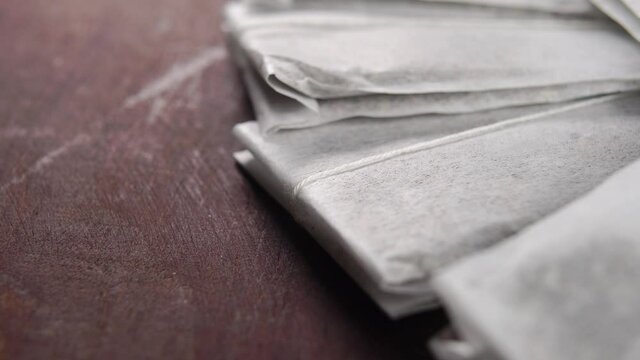 Paper bags with herbal tea on a old rustic wooden table. Macro. Rotation