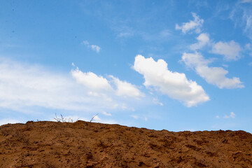 Big sand dune looking as mountain and blue sky with clouds on the background