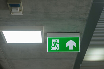 Fire Emergency exit sign on the wall inside building at subway train station. Safety concept