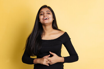 Obraz premium Emotional young adorable cute girl, student in black blouse posing isolated on yellow color studio backgroud