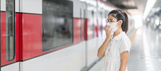 woman wearing Protective face mask prevention coronavirus inflection during waiting train. public...