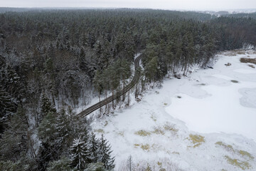 Aerial winter snowy view of forest road