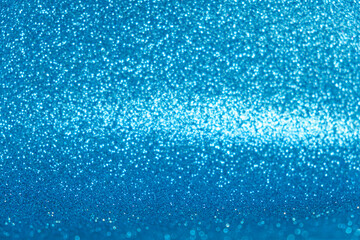 Fototapeta na wymiar An abstract blue background with sparkle lights and bokeh. Useful as Christmas background or greeting card.