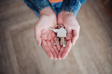 Woman with hands cupped holding house keys at home