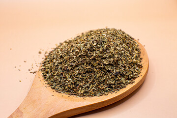 Dried oregana flakes wooden spoon