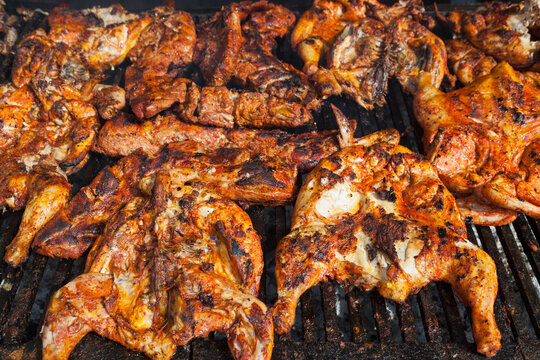 Chicken pieces cooking on a barbeque grill