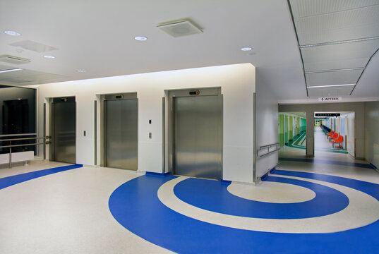 Elevators in the atrium of a new modern hospital, blue patterns on the floor