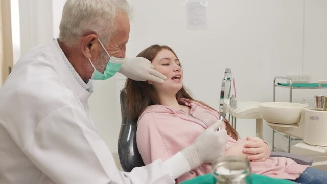 Closeup woman having dental teeth examined senior dentist check-up via excavator in Clinic her patient for beautiful smile.