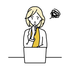 デスクで座ってPCを開いて困っているジャケットの女性