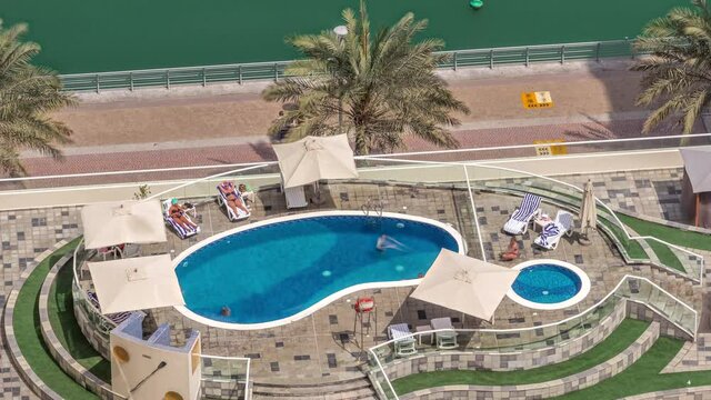 Rooftop swimming pool viewed from above timelapse, Aerial top view at Dubai marina.