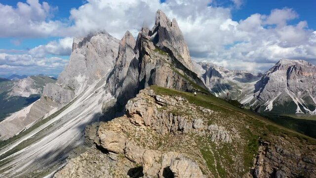 Man running at mountain Seceda in Dolomites, Italy. Picturesque Sky over the Odle Group Mountains. Val Gardena.
