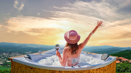 Girl traveler with a glass of wine enjoying relaxing pampering luxury weekend in a hot tub with...