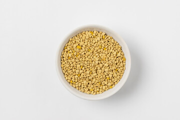 Macro photo of  top view flower bee pollen in a white ceramic bowl on white