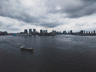 暗雲が立ち込める東京湾揚エリアと貨物船