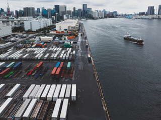 東京湾岸エリアの埠頭に置かれたコンテナと貨物船