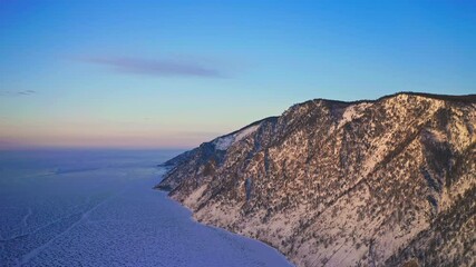 Aerial bird eye view. Snowy mountain at golden hour rounded with frozen ice lake - Powered by Adobe