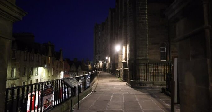 Edinburgh , East Lothian, circa 2021, Empty Victoria Street on a quiet night with traditional shops, the street lights cast gloomy shadows on the buildings lining the dark street