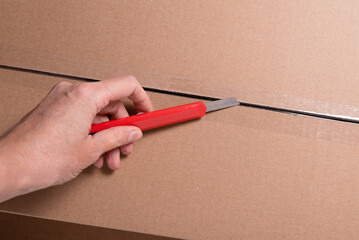 Paer knife on cardboard box for package opening