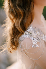 Bride shoulder in a sequin and beaded tulle dress. Close-up