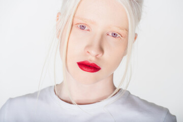 Portrait of albino woman with red lips in white t-shirt looking at camera isolated on white. - obrazy, fototapety, plakaty