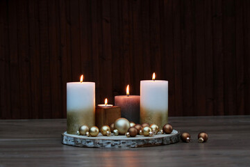Weihnachtshintergrund: Kerzen mit Weihnachtskugeln auf einer Baumscheibe.