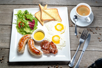 breakfast sausages with scrambled eggs toast and salad with sauce on a white plate on a wooden background
