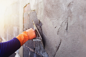Concrete plasterers to create industrial workers background walls with plastering tools.