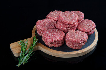 Raw beef meatballs made with various homemade spicy, beef kofta kofta raw, on black ground.