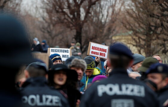 People attend a protest outside the Chancellery after the swearing-in of a new government, in Vienna