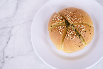 Garlic cream cheese bread or cheese bun, mozzarella cheese bun with sesame and parsley for serve on a white plate