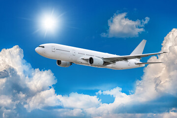 Fototapeta na wymiar White wide body passenger airplane flies in the air above scenic clouds