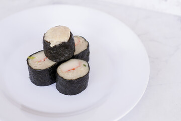 Chicken nori rolls or sushi rolls with shrimp, cheese, caviar, chicken, soy sauce, nori, wasabi on a white plate