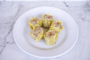 Japanese chicken dumplings Gyoza with carrot and vegetables, on a white plate