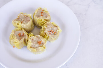 Japanese chicken dumplings Gyoza with carrot and vegetables, on a white plate