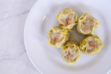 Japanese chicken dumplings Gyoza with carrot and vegetables, on a white plate