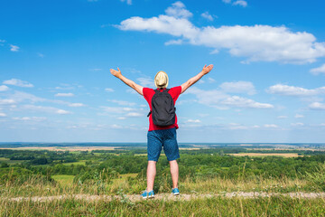 Fototapeta premium Young man admiring beautiful view of the forest landscape rear view.Young man standing alone summer day outdoors.