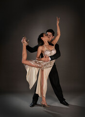 Studio shoot Latin woman and asian man dancing tango ballroom