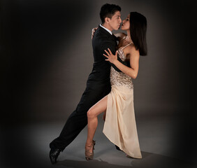 Studio shoot Latin woman and asian man dancing tango ballroom