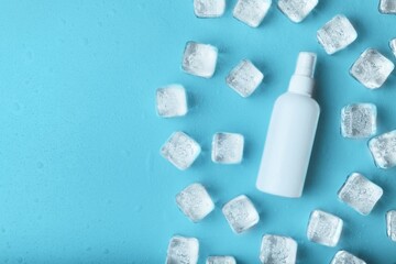 Cold cubes ice drops and spray on the blue background